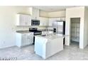 Modern kitchen with stainless steel appliances, a central island, and ample cabinet space at 1409 Gable Falls Pl # 89, North Las Vegas, NV 89084