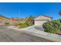 Charming single-story home features lush landscaping, a two-car garage, and desert surroundings at 2150 Maple Heights Ct, Henderson, NV 89052