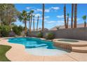 Beautiful pool and hot tub surrounded by palm trees and lush landscaping, perfect for outdoor entertaining at 4116 Villa Flora St, Las Vegas, NV 89130