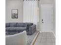 Comfortable living room with a gray sofa and natural light from the large window at 5512 Goldbrush St, Las Vegas, NV 89130