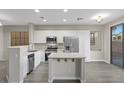 Bright, modern kitchen with stainless steel appliances, white cabinets, and a functional island with seating at 6460 Raven Hall St, North Las Vegas, NV 89084