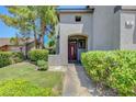 Inviting front entrance featuring a red door, green bushes and a paved walkway at 68 Vista Del Mar St, Henderson, NV 89012