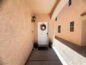 Inviting front entry featuring a decorated white door, a wall light and small potted plants at 6922 Majestic Palm Dr, Las Vegas, NV 89122