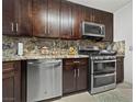 Modern kitchen featuring stainless steel appliances, a dishwasher, and elegant wood cabinetry at 7952 Lonette Ave, Las Vegas, NV 89147