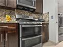 Modern kitchen showcasing stainless steel double oven and wooden cabinets at 7952 Lonette Ave, Las Vegas, NV 89147