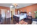 Cozy main bedroom with dark hardwood floors, a ceiling fan, windows and easy access to en suite bathroom at , Las Vegas, NV 89122