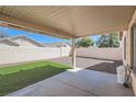 A covered patio with partial artifical turf and decorative gravel offers a perfect outdoor space at 1038 Silver Creek Ave, Las Vegas, NV 89183