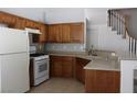 Traditional kitchen with honey-toned cabinets, white appliances, and neutral countertops at 1081 Elation Ln # 2, Henderson, NV 89002