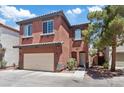 Two-story home with a terracotta stucco exterior, two-car garage, and a small balcony at 10918 Avenzano St, Las Vegas, NV 89141