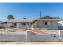 Front exterior of single story home featuring a desert landscape with cinderblock and wrought iron fence in front at 1108 Princess Katy Ave, Las Vegas, NV 89119