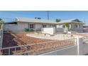 Exterior of single story home with low maintenance desert landscaping and cinderblock and wrought iron fence at 1108 Princess Katy Ave, Las Vegas, NV 89119