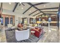 Open-concept living room with beamed ceilings, stylish furnishings, and lots of natural light at 12544 Claymore Highland Ave, Las Vegas, NV 89138