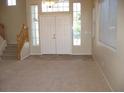 Welcoming foyer with tile flooring, staircase, and natural light from large windows at 254 Horizon Pointe Cir, Henderson, NV 89012