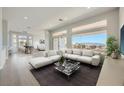 Bright living room with large windows boasting scenic views, paired with modern white furniture and sleek decor at 2904 Bow Bridge Dr, Las Vegas, NV 89134
