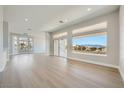 Bright open-concept living space with light wood flooring, large windows and view to mountains in background at 2904 Bow Bridge Dr, Las Vegas, NV 89134