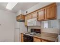 This modern kitchen features a range, a microwave, a refrigerator and wood cabinets at 3318 N Decatur Blvd # 2103, Las Vegas, NV 89130
