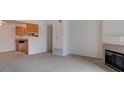 Carpeted living room features a fireplace, seamlessly flowing into the kitchen space at 3318 N Decatur Blvd # 2103, Las Vegas, NV 89130