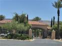 Gated community entrance with lush landscaping, tiled roof and desert mountain views at 4814 Regalo Bello St, Las Vegas, NV 89135