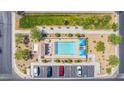 Overhead shot of a sparkling community pool with lounge chairs, umbrellas, and a nearby parking lot at 527 Clearsable Ave, Henderson, NV 89044