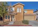 Two-story home featuring a charming front entrance, two-car garage, and low-maintenance desert landscaping at 5308 Carlsbad Heights St, North Las Vegas, NV 89081