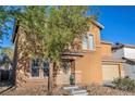 Two-story home featuring a charming front entrance, two-car garage, and low-maintenance desert landscaping at 5308 Carlsbad Heights St, North Las Vegas, NV 89081