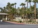 View of a community sign at the entrance surrounded by lush landscaping and mature palm trees at 7135 S Durango Dr # 106, Las Vegas, NV 89113