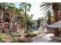 The pool area features a waterfall rock feature, palm trees, and comfortable seating at 7135 S Durango Dr # 106, Las Vegas, NV 89113