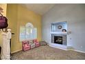 Inviting living room with a tiled fireplace, a large window with shutters, and neutral carpeting at 7728 Whispering River St, Las Vegas, NV 89131