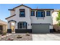 Inviting two-story home featuring a neutral color palette, rock garden, and an attached two-car garage at 8061 Palace Estate Ave, Las Vegas, NV 89117