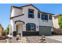 Charming two-story home featuring a cozy porch, an attractive rock garden, and a two-car garage at 8061 Palace Estate Ave, Las Vegas, NV 89117