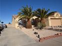 Inviting single-story home with a two-car garage, desert landscaping, and a paved driveway at 851 Brahma Ln, Henderson, NV 89002