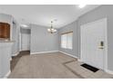 Inviting living room featuring tile flooring, a modern chandelier, and a bright entry at 8658 Tom Noon Ave # 103, Las Vegas, NV 89178