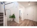 Bright foyer with wood-look flooring, a mirror, and a staircase leading to the upper level at 9256 Alden Pointe Ct, Las Vegas, NV 89143