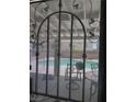 Backyard view through decorative ironwork onto a refreshing swimming pool and patio seating at 9511 Teton Vista Ave, Las Vegas, NV 89117