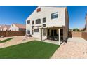 Landscaped backyard featuring artificial grass, desert landscaping, and a covered patio at 10952 Porto Foxi St, Las Vegas, NV 89141