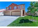 Beautiful home featuring a terracotta roof and two-car garage, complemented by green lawn and vibrant landscaping at 1663 Cloister Ave, Henderson, NV 89014