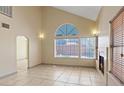 Bright, spacious living area with tile floors, a fireplace, and large windows at 1711 Ember Glow Cir, Las Vegas, NV 89119