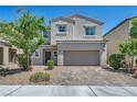 Charming two-story home with a two-car garage, desert landscaping and brick driveway at 2024 Mystic Wave Rd, North Las Vegas, NV 89031