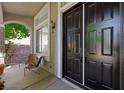 Inviting entryway featuring a stylish black door, a cozy sitting area, and plenty of natural light at 2229 Armacost Dr, Henderson, NV 89074