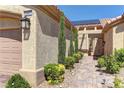 Inviting front entrance with decorative trees and shrubs along a brick paver walkway to the front door at 2605 Orchid Valley Dr, Las Vegas, NV 89134