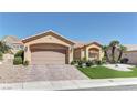 Lovely single-story home with a two-car garage, desert landscaping, and lush green lawn in front yard at 2605 Orchid Valley Dr, Las Vegas, NV 89134