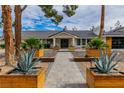 Charming home featuring a well-manicured front yard with decorative planters and a stone walkway at 3189 Montecito Dr, Las Vegas, NV 89120