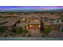 A dusk aerial view of the home showcases its tile roof, brick accents, and a two-car garage nestled in a neighborhood at 342 Molinetto St, Las Vegas, NV 89138