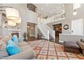 Spacious living room with a fireplace, hardwood floors, and a two-story foyer with staircase at 364 Trentino Alto St, Henderson, NV 89012