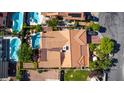A high-angle view reveals a home with a terracotta-tiled roof, lush landscaping, and a sparkling pool at 3877 Platis Cir, Las Vegas, NV 89103