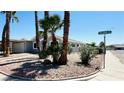 Street view of home with covered parking, desert landscaping, and palm trees at 4238 Boratko St, Las Vegas, NV 89115