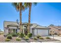 Charming single-story home with a well-manicured front yard and mature palm trees at 5000 Linkside Dr, Las Vegas, NV 89130