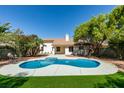 Inviting backyard with a freeform pool, spa, and lush landscaping, perfect for outdoor entertaining at 6126 Bedrock Ct, North Las Vegas, NV 89031