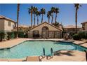 Community pool surrounded by palm trees and lounge chairs for relaxation on a sunny day at 6808 Indian Chief Dr # 204, Las Vegas, NV 89130