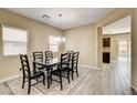 Bright dining room featuring stylish wood-look tile, a modern chandelier, and access to the backyard at 6897 Linda Creek Ct, Las Vegas, NV 89178